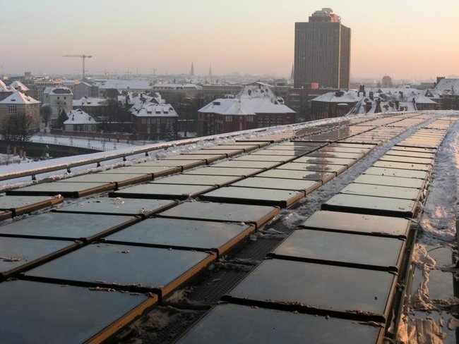 Industriekletterer bei der Schneebeseitigung auf einem Gebäudedach im Winter