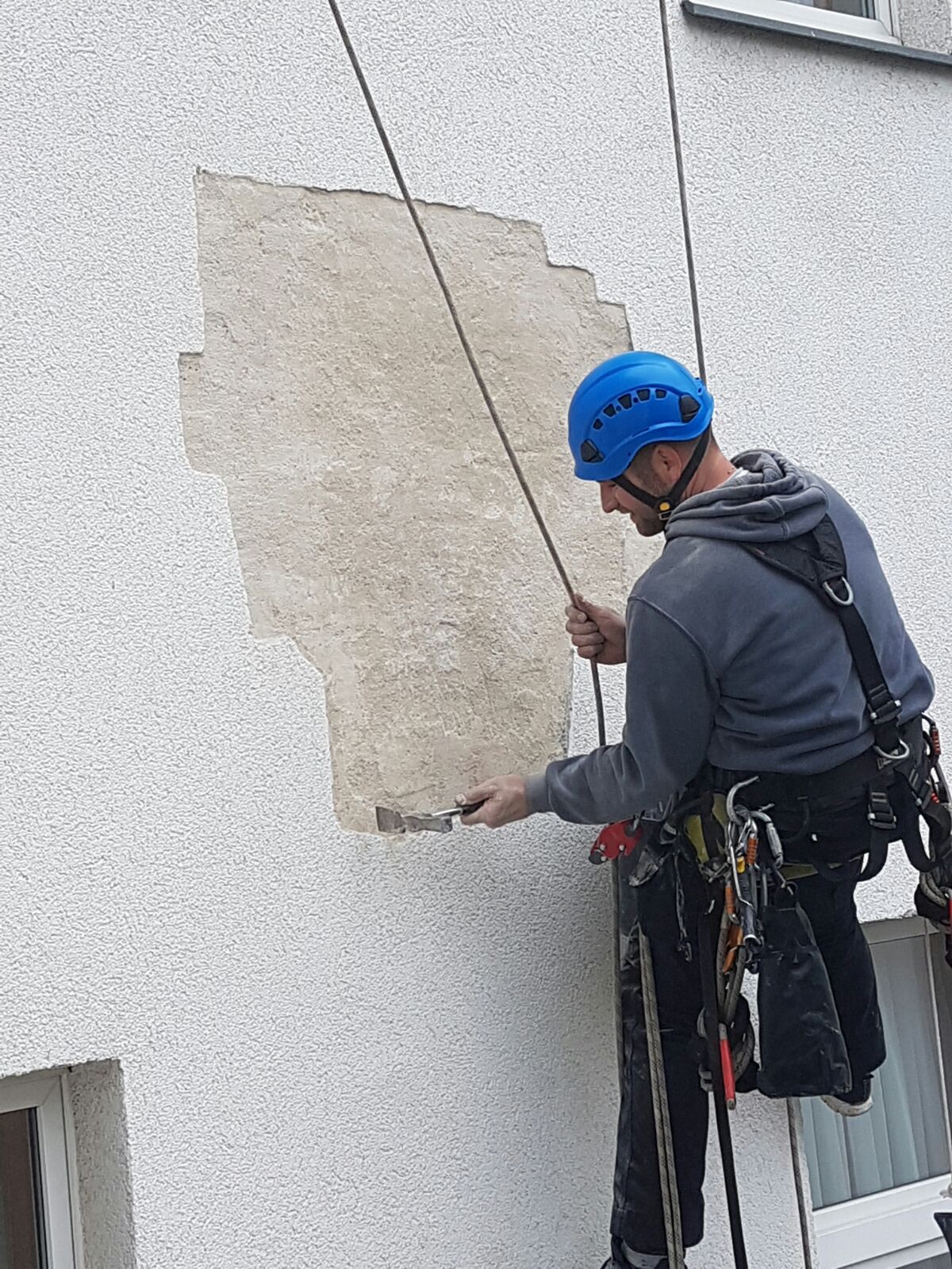 Industriekletterer der ZITRAS GmbH führen Verputzarbeiten bei einer Fassadensanierung durch